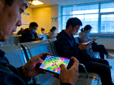 等待场景图，展示人们在医院或车站等待时使用手机游戏的画面